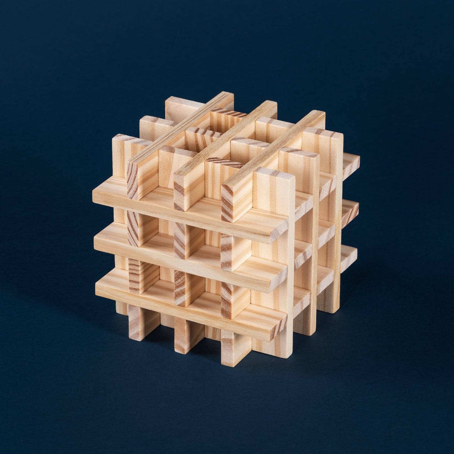 Komplexe dreidimensionale Struktur aus Holzklötzen auf dunkelblauem Hintergrund