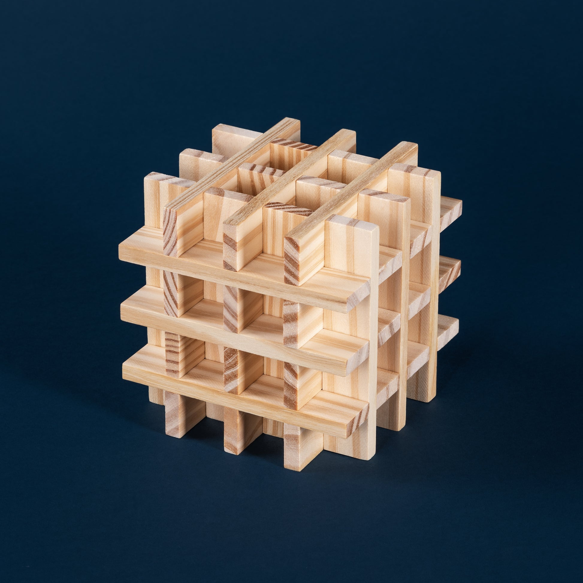 Komplexe dreidimensionale Struktur aus Holzklötzen auf dunkelblauem Hintergrund